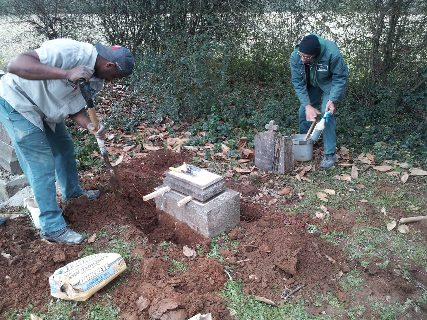 Two Men Digging a Hole for a Tombstone