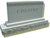 A memorial slab with the name and illustration by the text Coggins