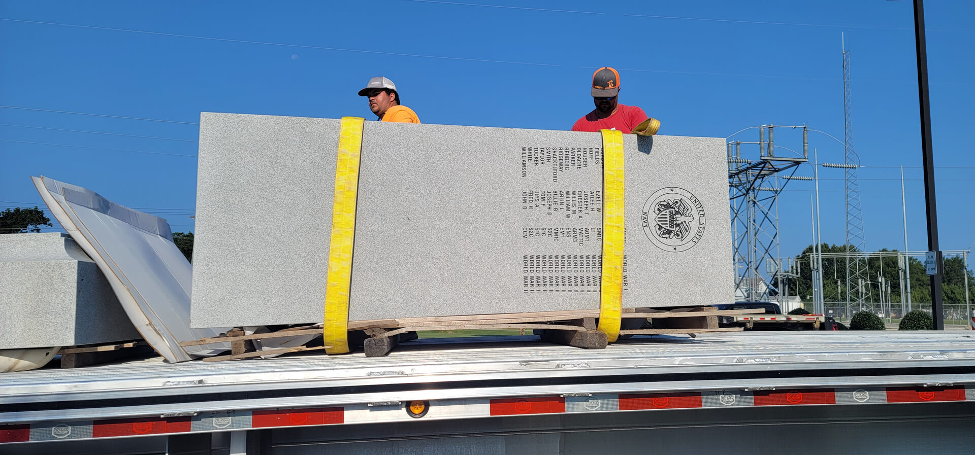 A Crane Lifting a Memorial Plaque From a Truck