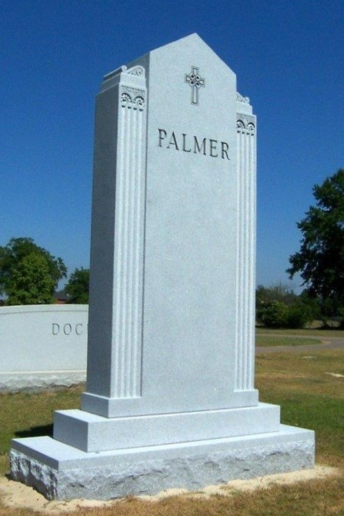 A memorial slab with the name Palmer and a cross sign