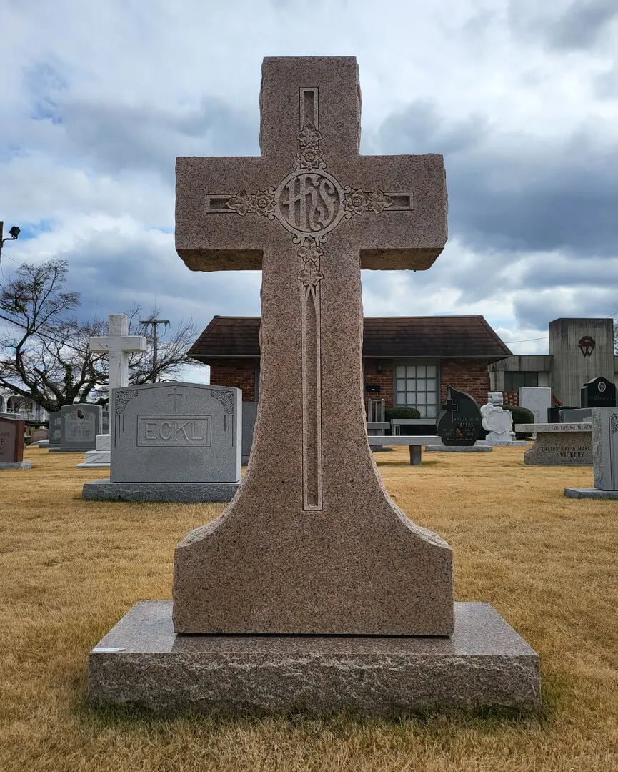 A cross shaped memorial slab design with brown granite