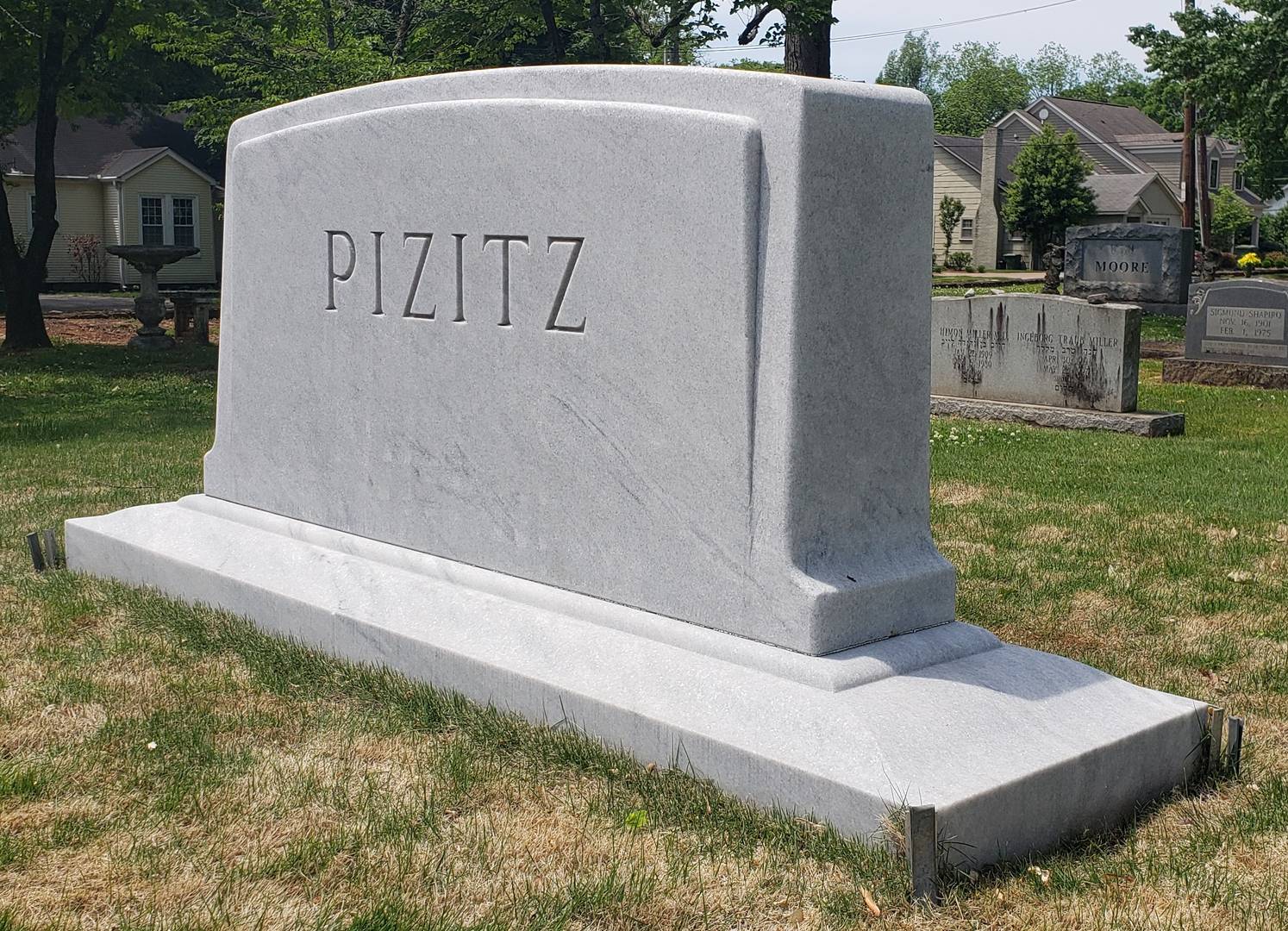 A memorial slab with the name and illustration by the text Pizitz