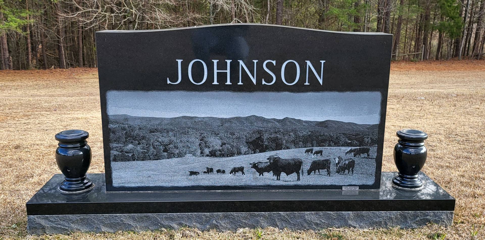 A memorial slab with the name and illustration by the text Johnson with cattle picture