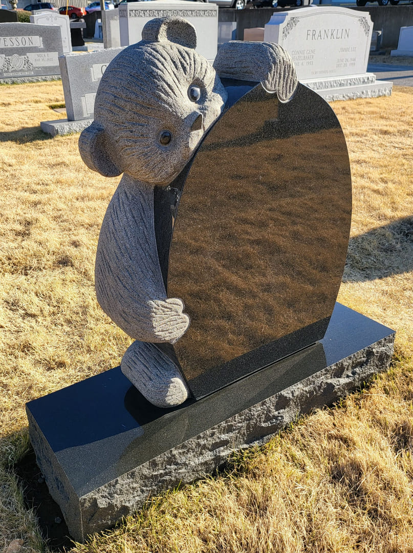 A Bear Holding a Heart Statue Tombstone