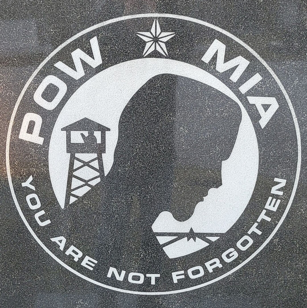 A signboard that says Pow MIA and illustration of a man