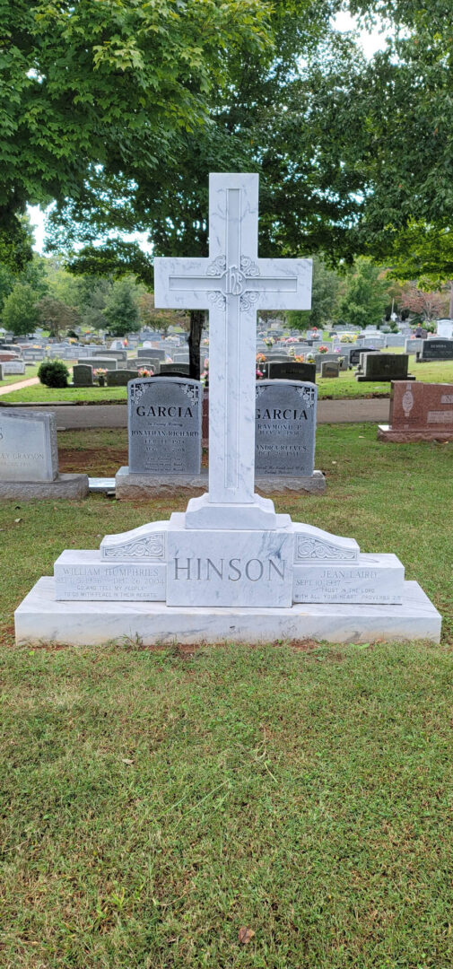 A cross shaped memorial slab with the name Hinson at the graveyard