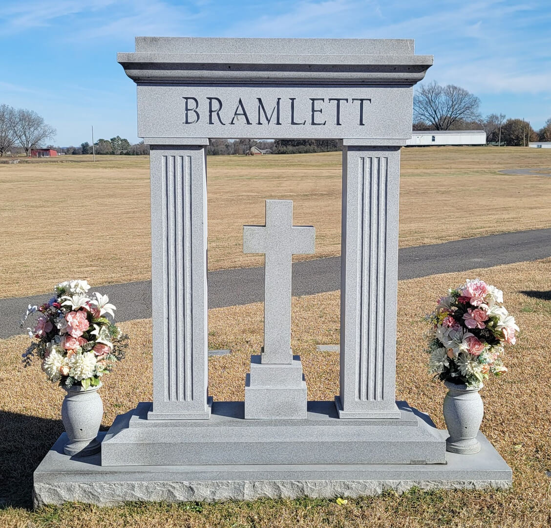 A cross shaped memorial slab with the name Bramlett