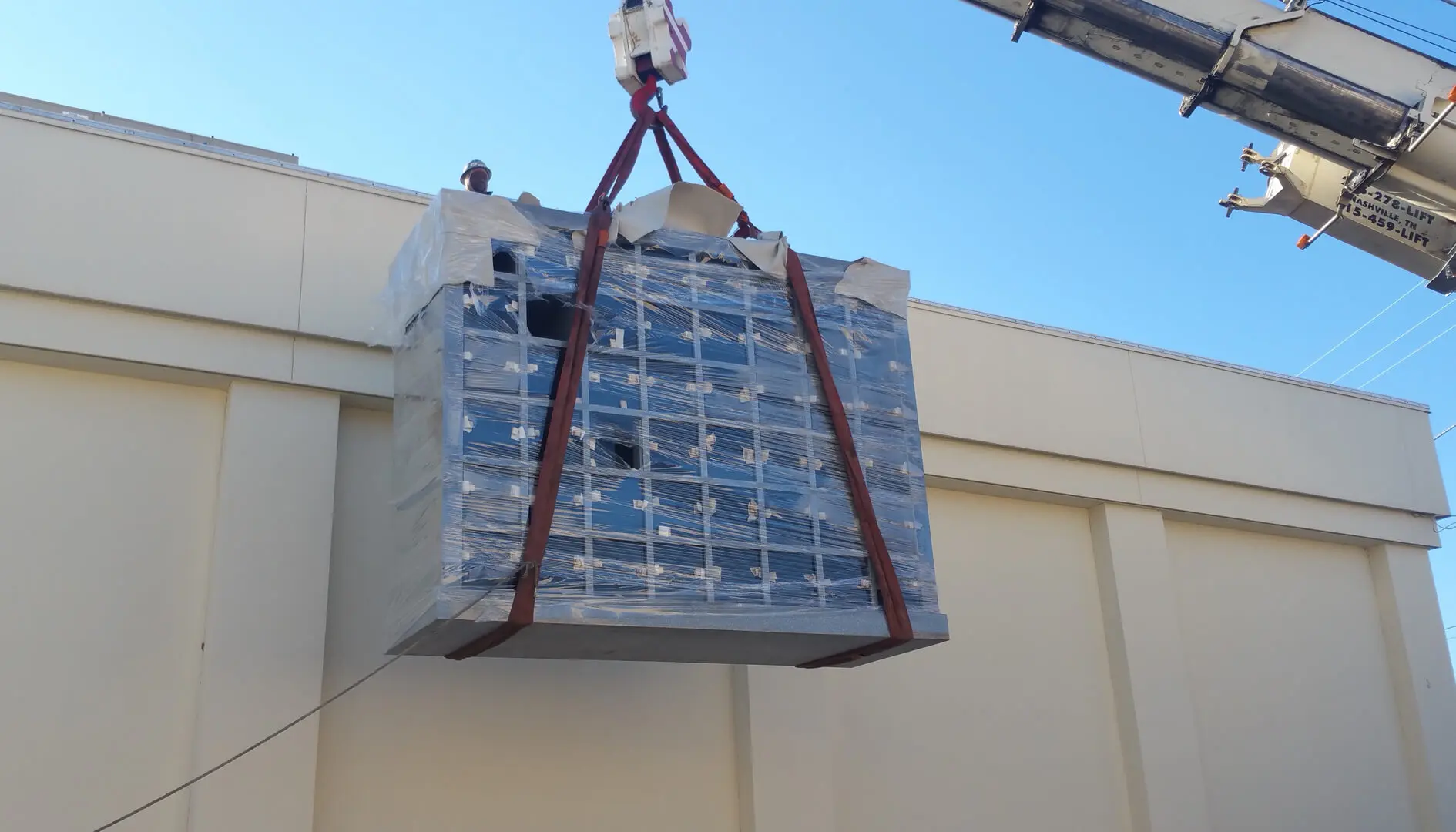 A Crane Carrying a Marble Block in Air With Strings