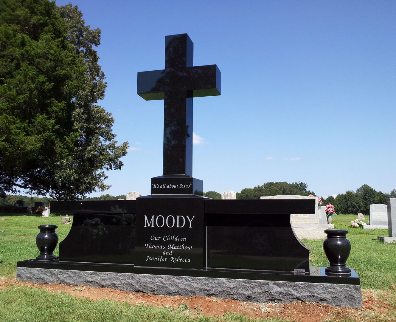 A cross shaped memorial slab with the name Moody
