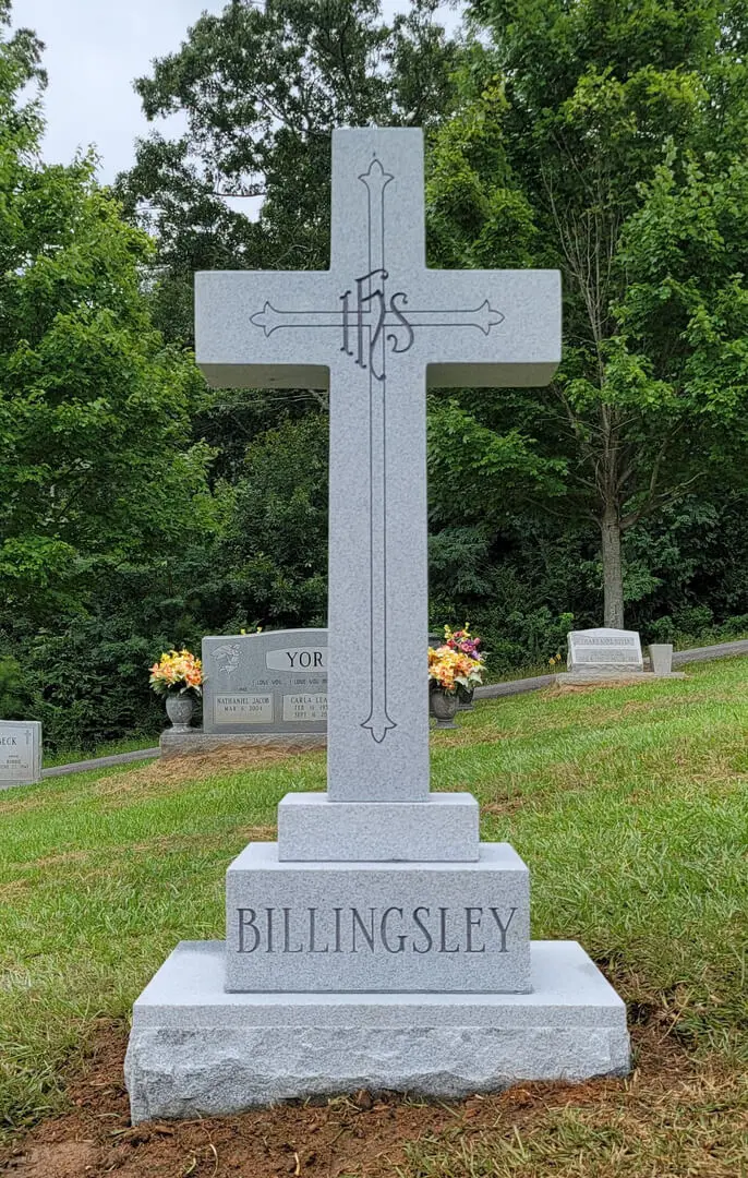 A cross shaped memorial slab with the name Bellingsley