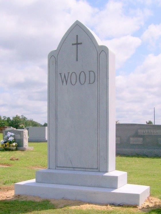 A memorial slab with the name Wood and a cross sign