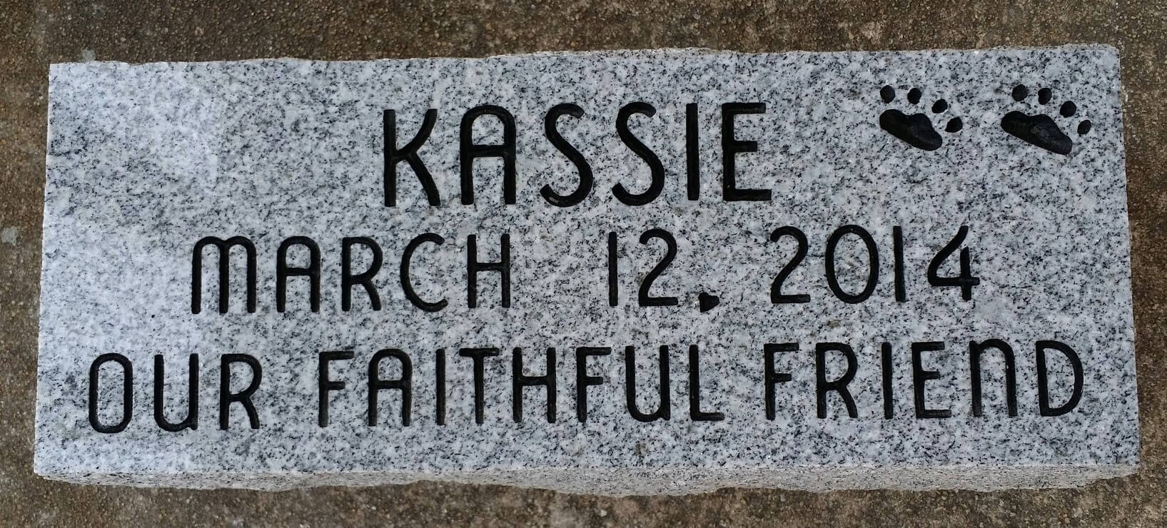 A memorial slab for the pet with the name Kassie
