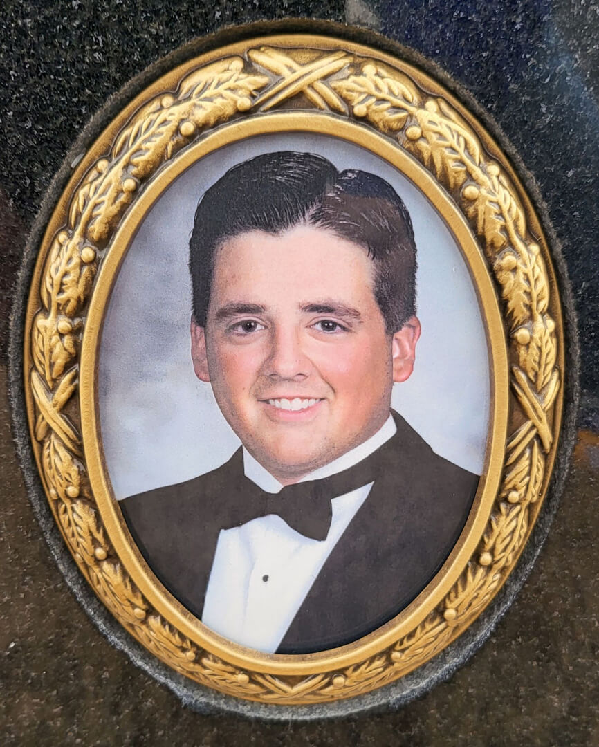 A picture of a man wearing a tuxedo engraved on a memorial slab