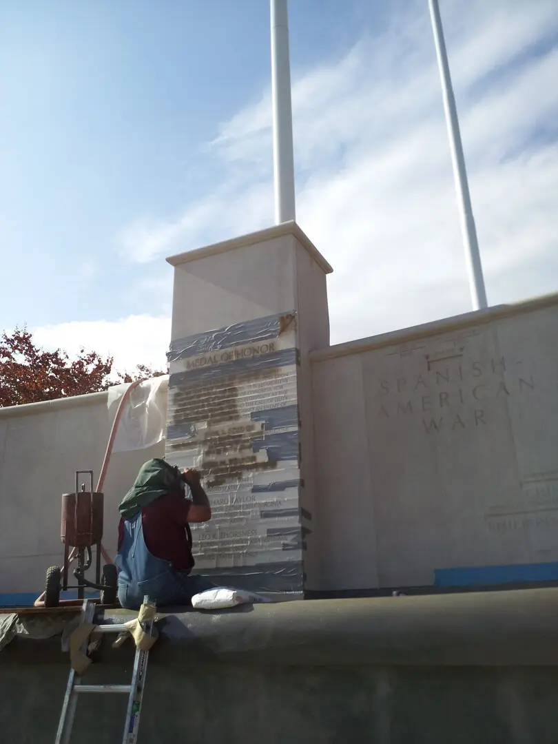 A Man Painting a Memorial Block