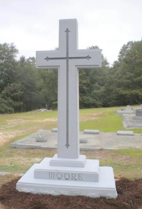 A cross shaped memorial slab with the name Moore
