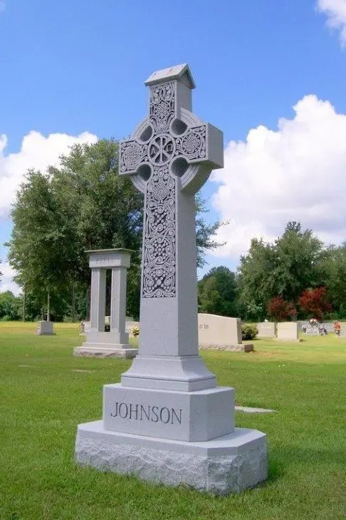A cross shaped memorial slab with the name Johnson