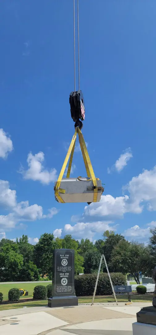 A Crane Lifting a Cement Stone in the Air