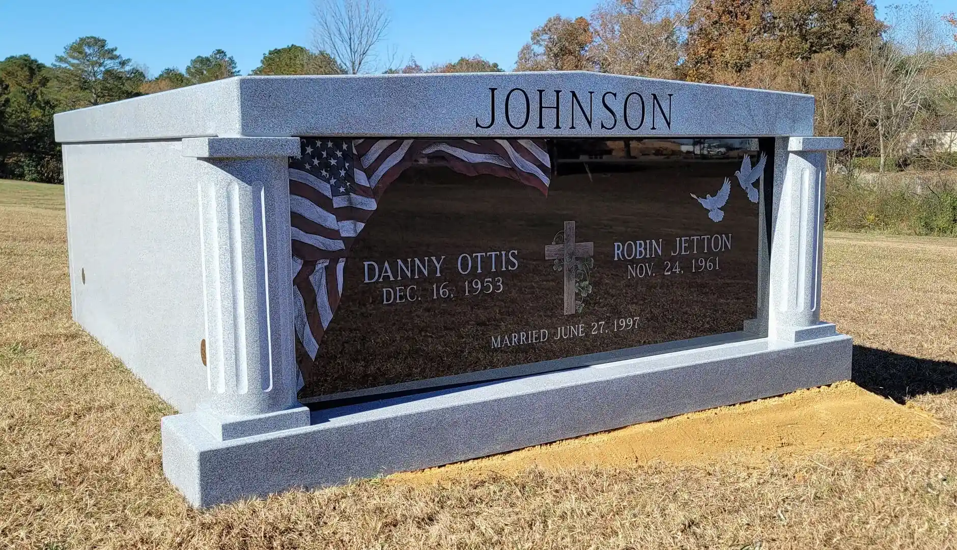 A memorial slab with the name Johnson and illustration of American flag