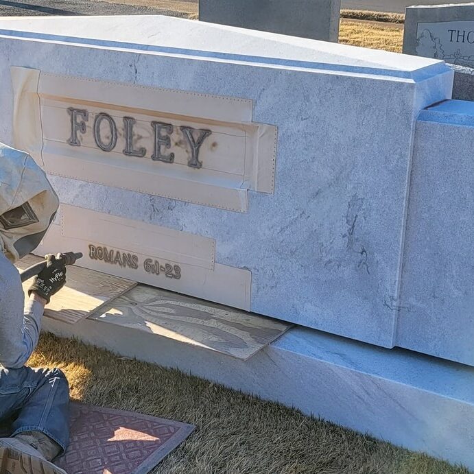 Clark memorial work doing marking on headstone with his equipment